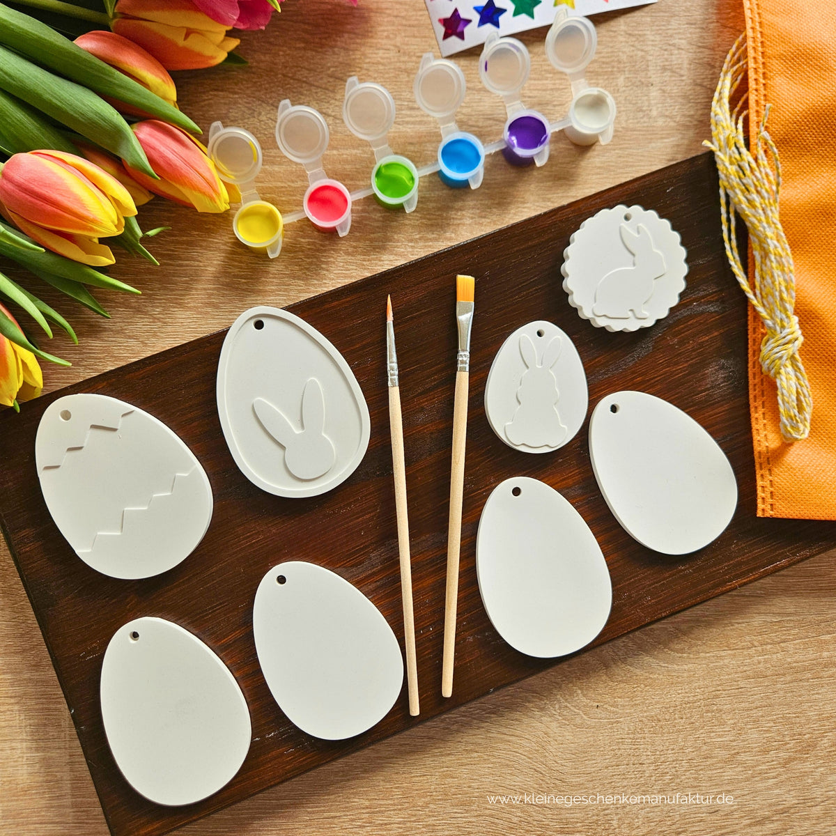 Osterbaumschmuck zum Bemalen für Kinder mit acht handgegossenen Osteranhängern in verschiedenen Formen und Größen. Das Oster Malset enthält Farben, zwei Pinsel, Sticker und Schnüre zum kreativen Gestalten der eigenen Osterdeko.